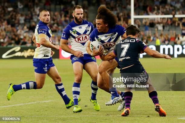 Raymond Faitala-Mariner of the Bulldogs fends off Brodie Croft of the Storm during the round one NRL match between the Canterbury Bulldogs and the...