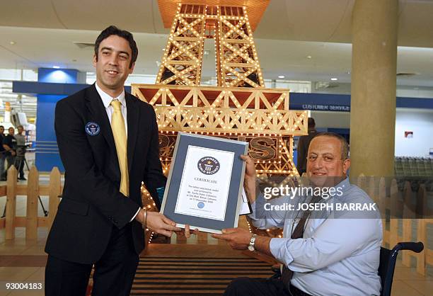 British Jack Brockbank , an international adjudicator from Guinness World Records, presents a certificate to wheelchair-bound Lebanese craftsman...