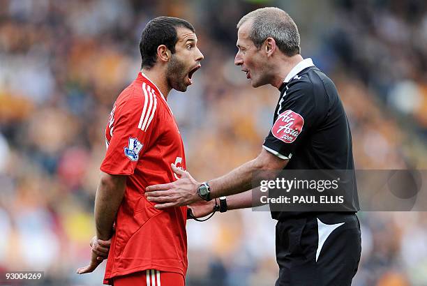 Liverpool's Argentinian midfielder Javier Mascherano is spoken to by referee Martin Atkinson during the English Premier League football match between...