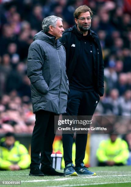 Jose Mourinho, Manager of Manchester United and Jurgen Klopp, Manager of Liverpool speak during the Premier League match between Manchester United...