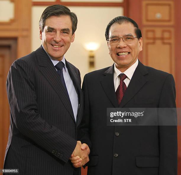 Visiting French Prime Minister Francois Fillon shakes hands with Vietnamese Communist Party Secretary General Nong Duc Manh as they meet at the VCP's...