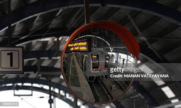 New metro train is reflected in a mirror prior to its flagging off to Noida from the Akshardham Metro Station in New Delhi on November 12, 2009....