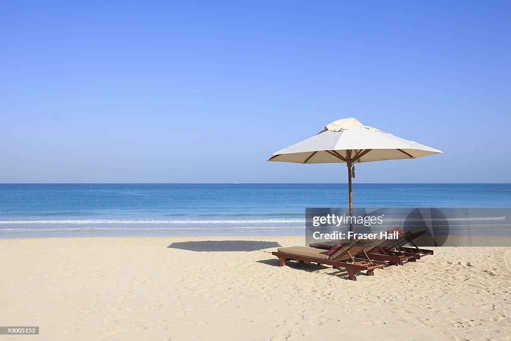 Sunlounger and umbrella on an empty beach