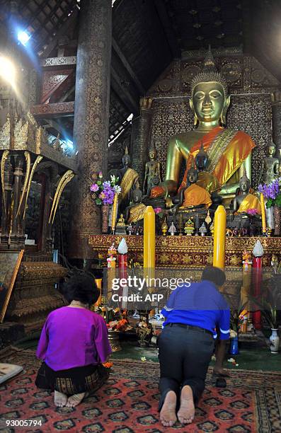 Buddhist tourists pray inside Wat Xieng Thong, one of Luang Prabang's main temples, on October, 18 2009. The 700-year-old former capital, seen as the...