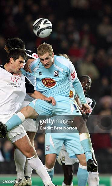 Gary Mulligan of Northampton Town challenges for the ball with Mark Carrington of MK Dons during the Johnstone's Paint Trophy Southern Area Quarter...