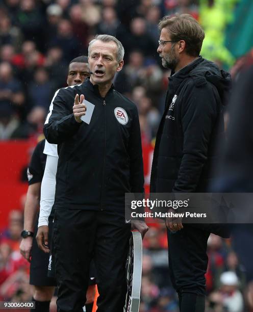 Manager Jurgen Klopp of Liverpool is spoken to by fourth official Martin Atkinson during the Premier League match between Manchester United and...