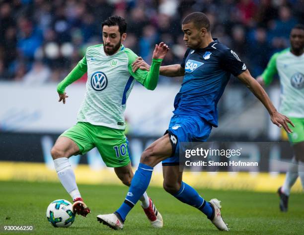 Yunus Malli of Wolfsburg is challenged by Kevin Akpoguma of Hoffenheim during the Bundesliga match between TSG 1899 Hoffenheim and VfL Wolfsburg at...