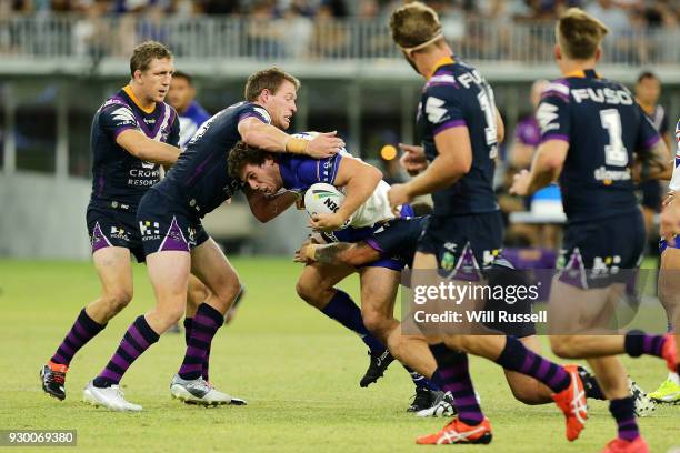 Adam Elliott of the Bulldogs is tackled during the round one NRL match between the Canterbury Bulldogs and the Melbourne Storm at Optus Stadium on...