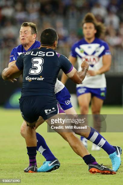 Josh Morris of the Bulldogs is tackled by Will Chambers of the Storm during the round one NRL match between the Canterbury Bulldogs and the Melbourne...