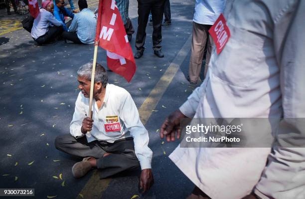 Supporter sits holding the CPI flag, as members of the Communist Party of India CPI and other Leftist parties protest against Bhartiya Janta Party in...