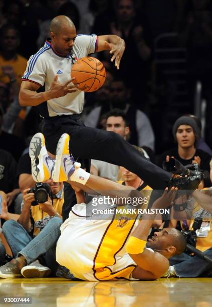 Kobe Bryant of the Los Angeles Lakers nearly collides with the referee after falling when blocked by Orlando Magic players during game two of the NBA...