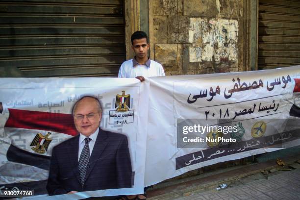 Supporters of Presidential candidate and leader of the Liberal el-Ghad Party, Moussa Mostafa Moussa, hold his campaign banners during a pre-election...