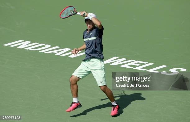 Yoshihito Nishioka of Japan follows through on a forehand to Marcos Baghdatis of Cyprus during the BNP Paribas Open at the Indian Wells Tennis Garden...