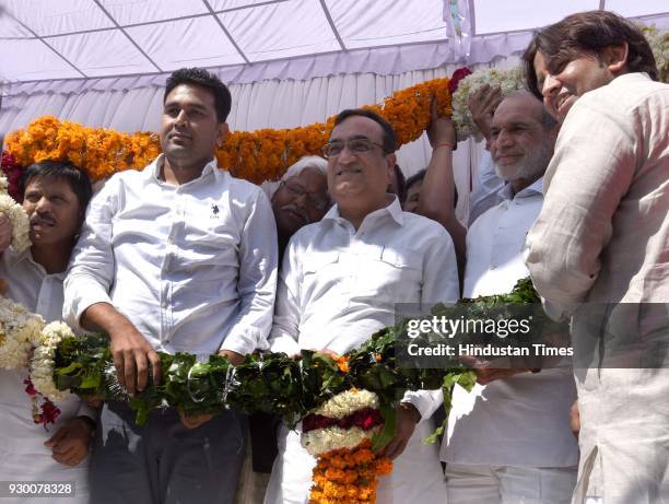 Newly-elected Delhi Youth Congress President Vikas Chhikara and DPCC president Ajay Maken being garlanded during an oath-taking ceremony at the DPCC...