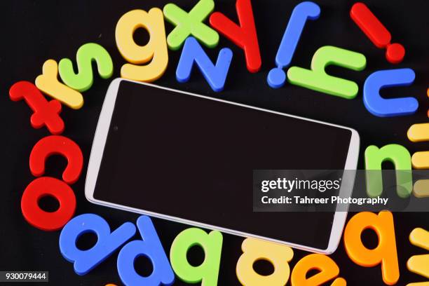 mobile phone placed among alphabet blocks - wrong tool stock pictures, royalty-free photos & images