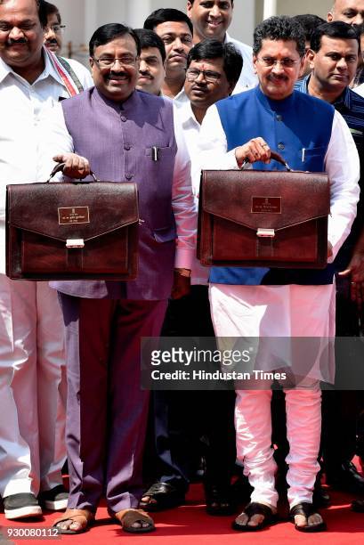 State Finance Minister Sudhir Mungantiwar and Minister for State for Finance Deepak Kesarkar stand for a photo opportunity before presenting the...