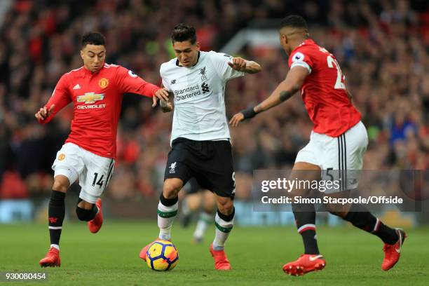 Roberto Firmino of Liverpool battles with Jesse Lingard of Man Utd and Luis Antonio Valencia of Man Utd during the Premier League match between...