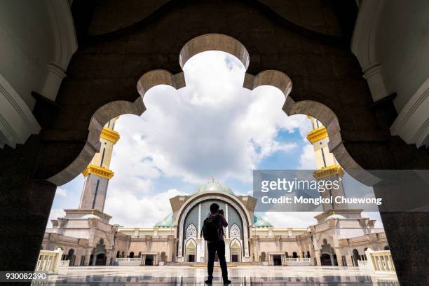 photographer take a photo in masjid wilayah persekutuan or mosque wilayah at kuala lumpur malaysia - arabesque position ストックフォトと画像