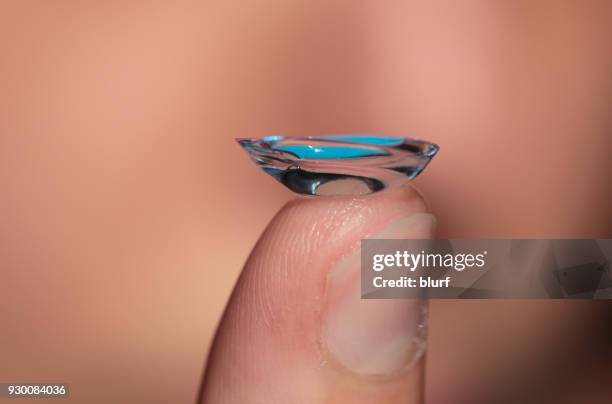 close-up of a contact lens on a womans finger - lente de contacto fotografías e imágenes de stock