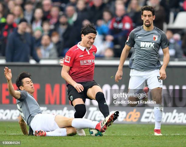 Miiko Albornoz of Hannover is challenged by Ja-Cheol Koo of Augsburg during the Bundesliga match between Hannover 96 and FC Augsburg at HDI-Arena on...