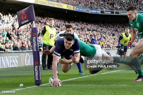 Scotland's wing Blair Kinghorn dives to scores his team's first try during the Six Nations international rugby union match between Ireland and...