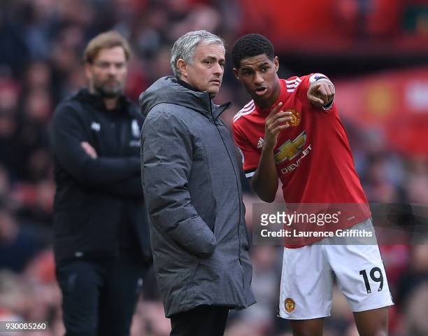 Jose Mourinho of Manchester United speaks to Marcus Rashford as Jurgen Klopp of Liverpool looks on during the Premier League match between Manchester...