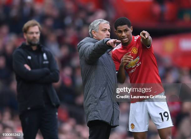 Jose Mourinho of Manchester United speaks to Marcus Rashford as Jurgen Klopp of Liverpool looks on during the Premier League match between Manchester...