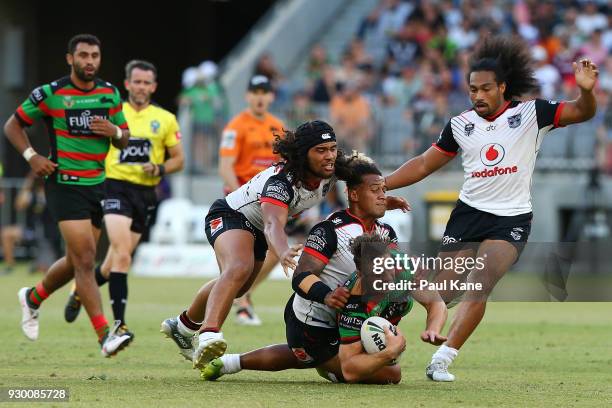 Cameron Murray of the Rabbitohs gets tackled by Isaiah Papali'i and James Gavet of the Warriors during the round one NRL match between the South...