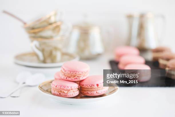strawberry and chocolate macaroons with teacups - macaron photos et images de collection
