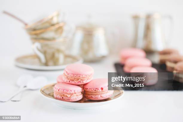 strawberry and chocolate macaroons with teacups - アフタヌーンティー ストックフォトと画像