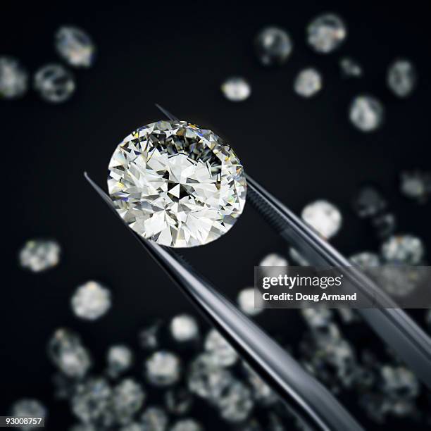 diamond held by tweezers - diamante foto e immagini stock