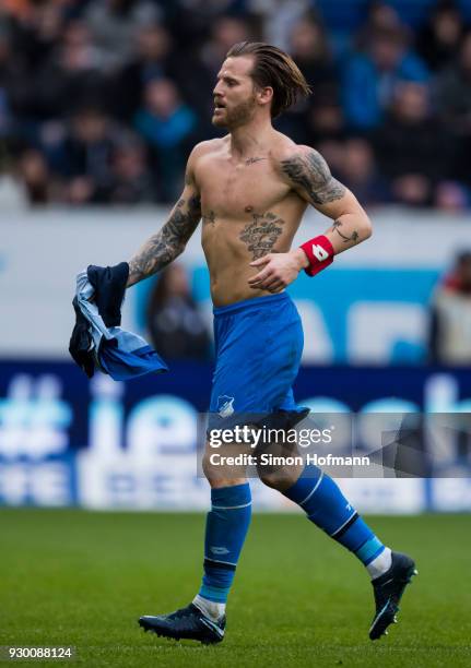 Eugen Polanski of Hoffenheim is removing his damaged jersey to replkace it with a new one during the Bundesliga match between TSG 1899 Hoffenheim and...