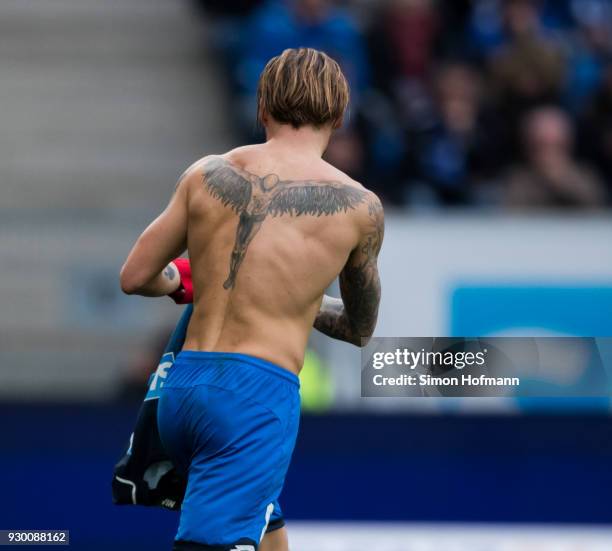 Eugen Polanski of Hoffenheim is removing his damaged jersey to replkace it with a new one during the Bundesliga match between TSG 1899 Hoffenheim and...