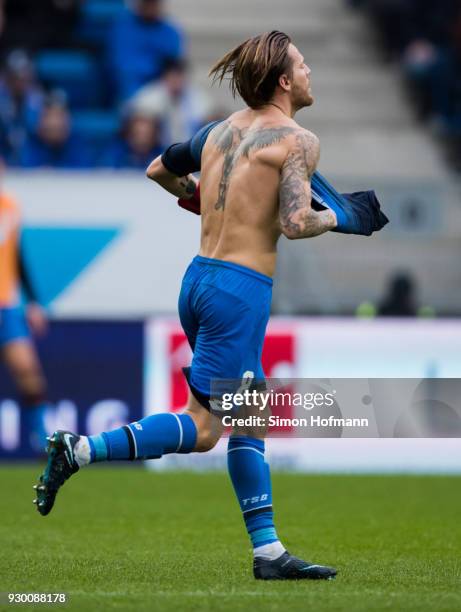 Eugen Polanski of Hoffenheim is removing his damaged jersey to replkace it with a new one during the Bundesliga match between TSG 1899 Hoffenheim and...