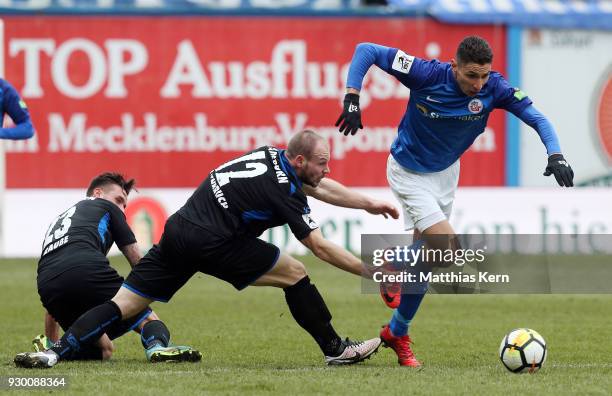 Robin Krausse, Felix Herzenbruch and Soufian Benyamina battle for the ball during the 3.Liga match between FC Hansa Rostock and SC Paderborn 07 at...