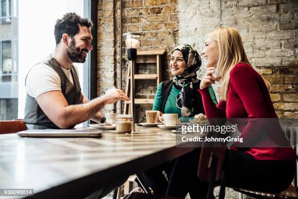 gruppe von freunden chatten in coffee-shop - sprechen zusammen cafe stock-fotos und bilder