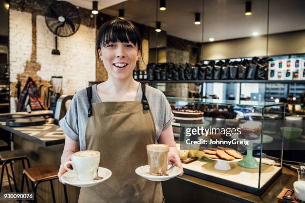 jonge vrouw die werkt in café met warme dranken - deeltijdbaan stockfoto's en -beelden