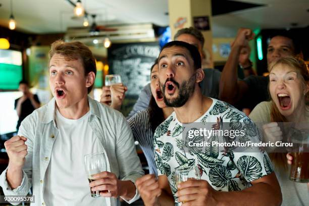 soccer fans watching match together at pub - sports bar stock pictures, royalty-free photos & images
