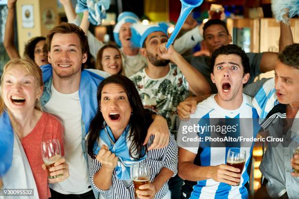 argentinian soccer fans watching match together at pub - argentina supporters stock pictures, royalty-free photos & images