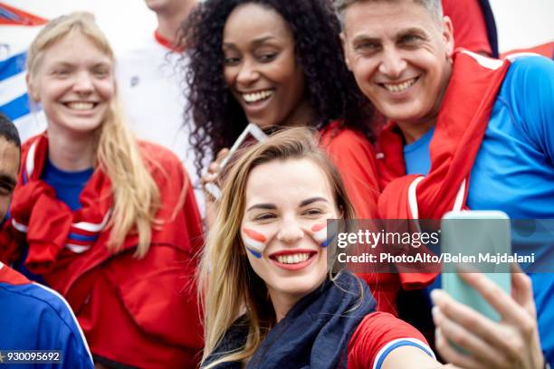 french football fan taking a selfie at football match - geschminkt gezicht stockfoto's en -beelden