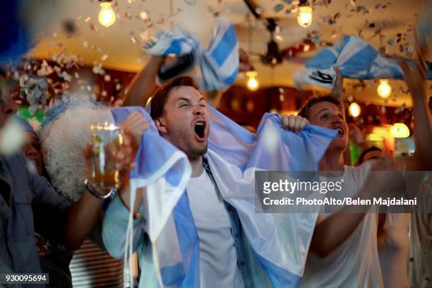 argentinian football fans celebrating victory in bar - fan stock-fotos und bilder