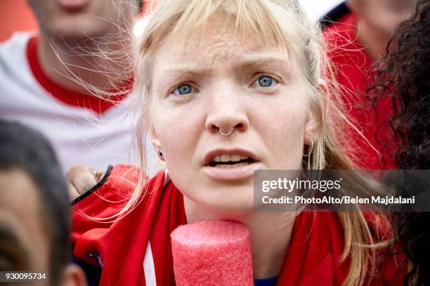 woman watching football match with furrowed brow, portrait - headshots soccer stock-fotos und bilder