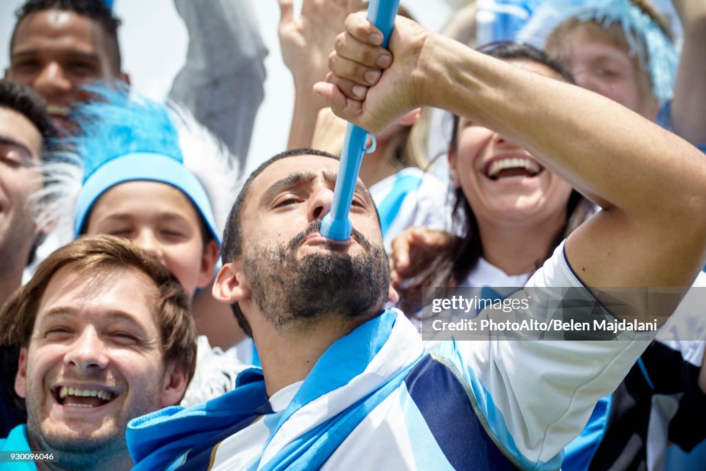 Argentinian football fan playing vuvuzela at match