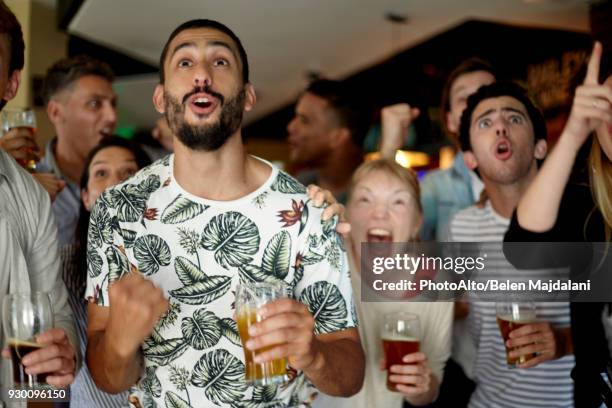 sports enthusiasts excitedly watching match in bar - before the party stock pictures, royalty-free photos & images