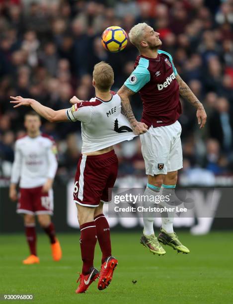 Marko Arnautovic of West Ham United wins a header over Ben Mee of Burnley during the Premier League match between West Ham United and Burnley at...