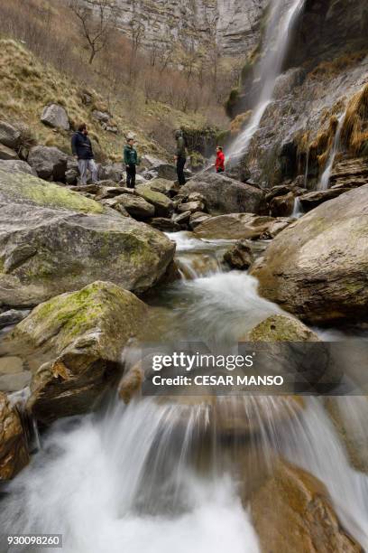 People walk through the canyon of the Salto del Nervion waterfall near Berberana in the Spanish province of Burgos on March 10, 2018. The...