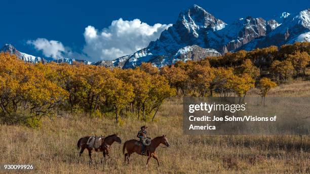 Older Cowboy, Howard Linscott , leads packhorse across historic Last Dollar Ranch on Hastings Mesa, SW Colorado, San Juan Mountains.