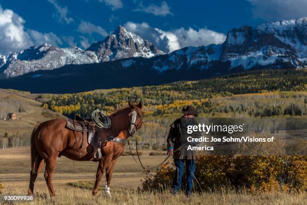 Older Cowboy, Howard Linscott , leads packhorse across historic Last Dollar Ranch on Hastings Mesa, SW Colorado, San Juan Mountains.