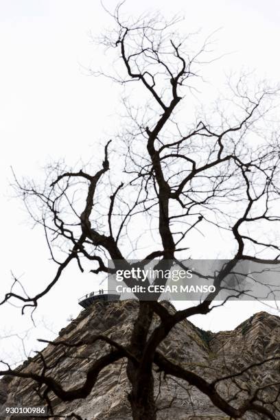 People stand on a platform overlooking the Salto del Nervion waterfall near Berberana in the Spanish province of Burgos on March 10, 2018. The...