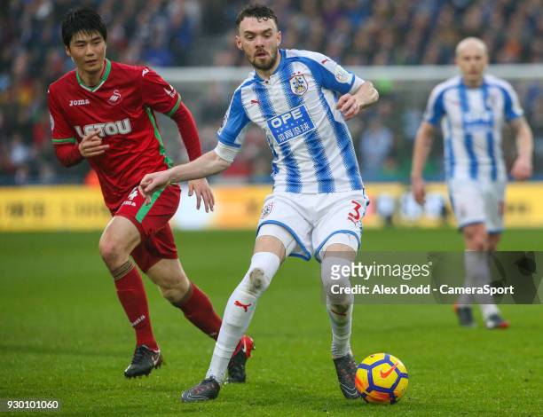 Huddersfield Town's Scott Malone gets away from Swansea City's Ki Sung-Yueng during the Premier League match between Huddersfield Town and Swansea...